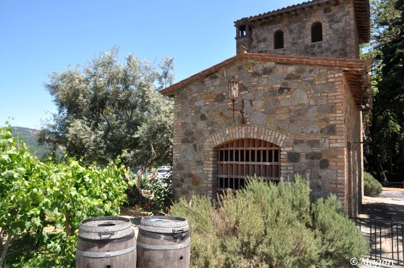Castello Di Amorosa: каменная башня с решётчатым окном и винными бочками